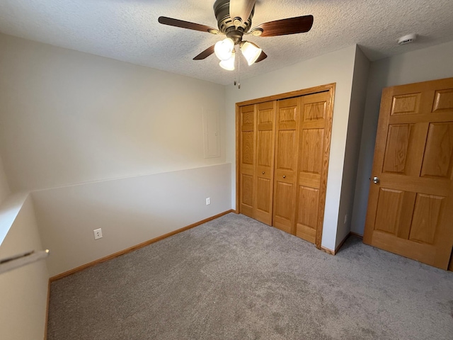 unfurnished bedroom with ceiling fan, a textured ceiling, light carpet, and a closet