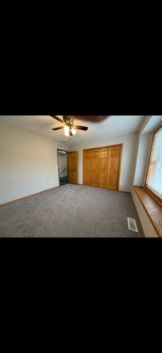 interior space with ceiling fan and carpet floors