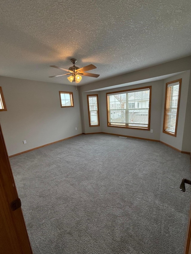 spare room with ceiling fan, carpet floors, and a textured ceiling