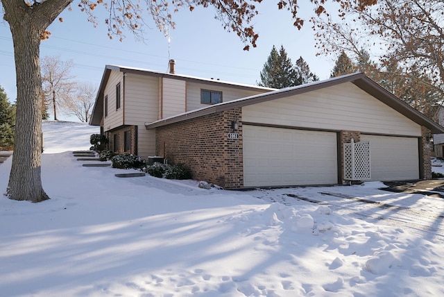 view of snowy exterior featuring a garage