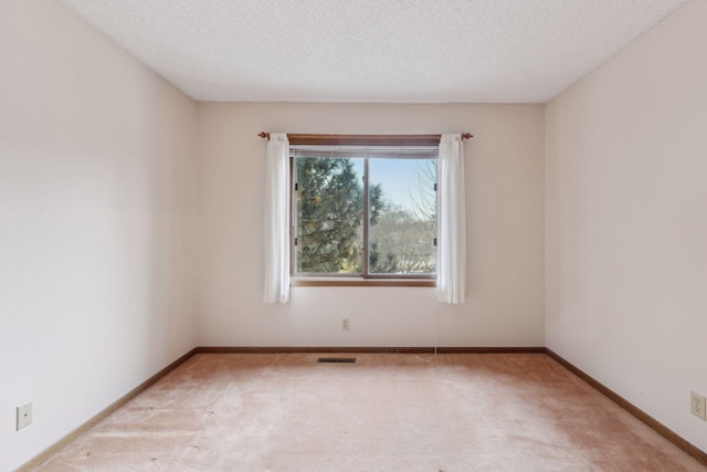 carpeted spare room featuring a textured ceiling