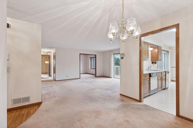 carpeted spare room featuring a textured ceiling, a notable chandelier, and sink