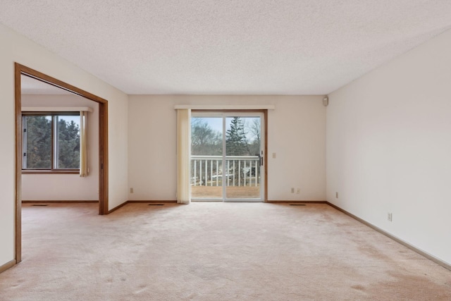 unfurnished room featuring light carpet and a textured ceiling