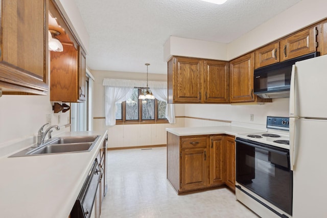 kitchen with sink, kitchen peninsula, pendant lighting, a chandelier, and white appliances