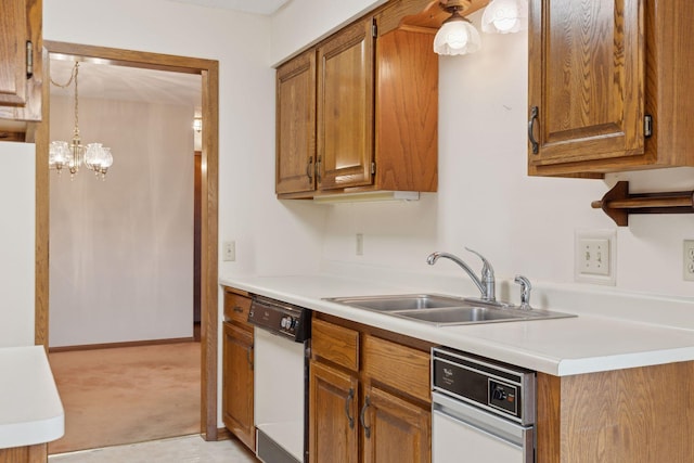 kitchen featuring a chandelier, sink, white dishwasher, and pendant lighting