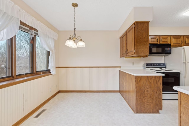 kitchen featuring electric range, an inviting chandelier, kitchen peninsula, wood walls, and decorative light fixtures