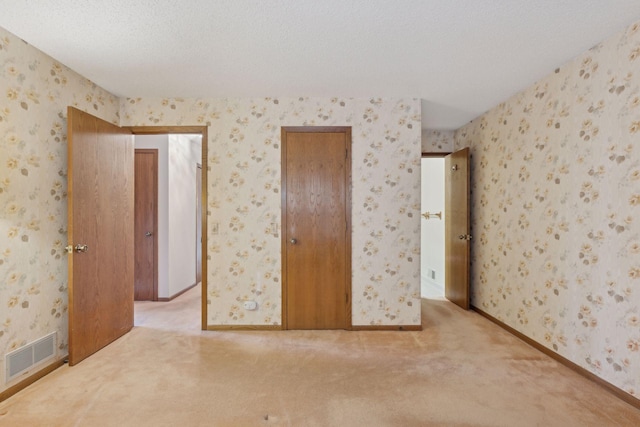 unfurnished bedroom with carpet flooring and a textured ceiling