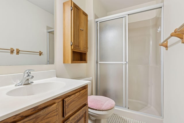 bathroom featuring vanity, a shower with shower door, and toilet