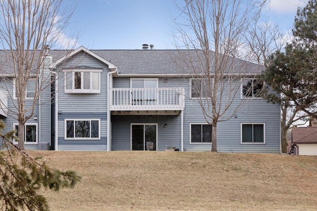 rear view of house featuring a yard and a balcony