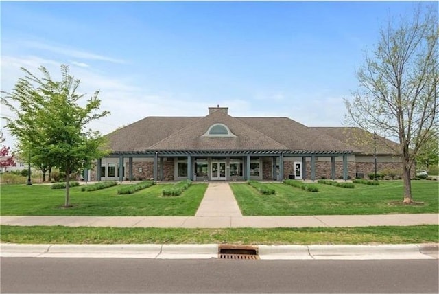 view of front of house with a front lawn, brick siding, and a pergola