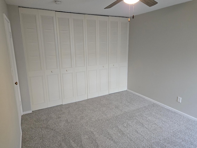 unfurnished bedroom featuring carpet, ceiling fan, and a closet