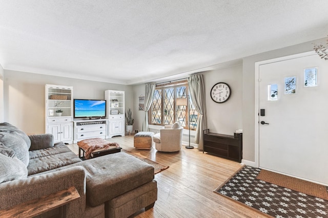 living room featuring a textured ceiling and light hardwood / wood-style floors