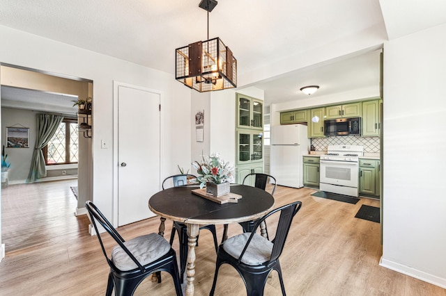 dining area featuring light wood-type flooring and a chandelier