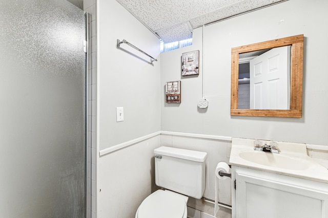 bathroom with walk in shower, a drop ceiling, vanity, and toilet