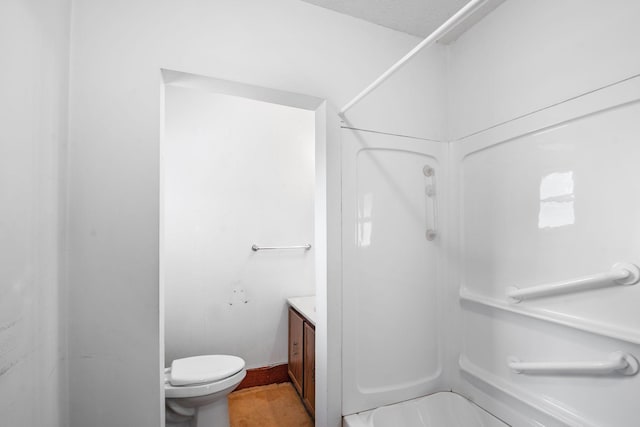 bathroom featuring a shower, vanity, and toilet