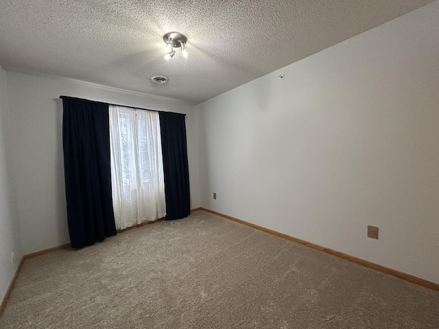 carpeted spare room featuring a textured ceiling