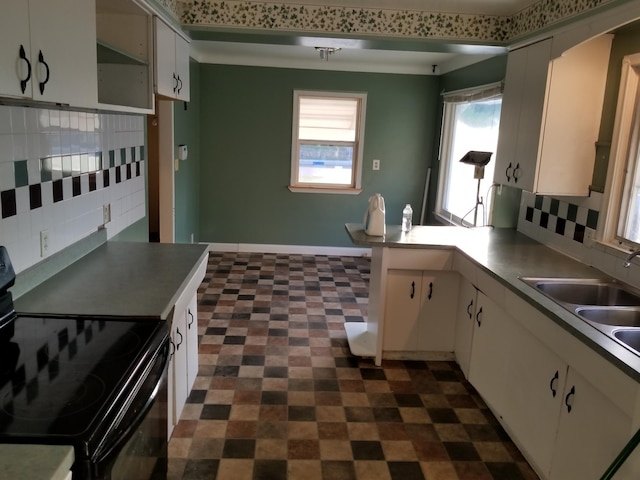 436 6th Ave SW, Cambridge, MN 55008 - kitchen with black / electric stove, decorative backsplash, a peninsula, dark floors, and white cabinetry
