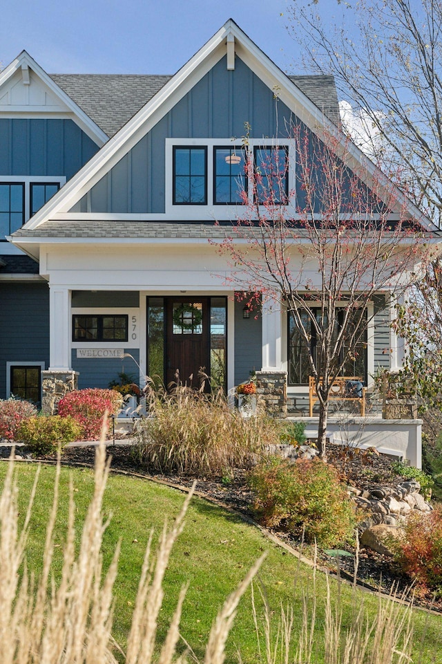 craftsman-style house featuring covered porch and a front yard