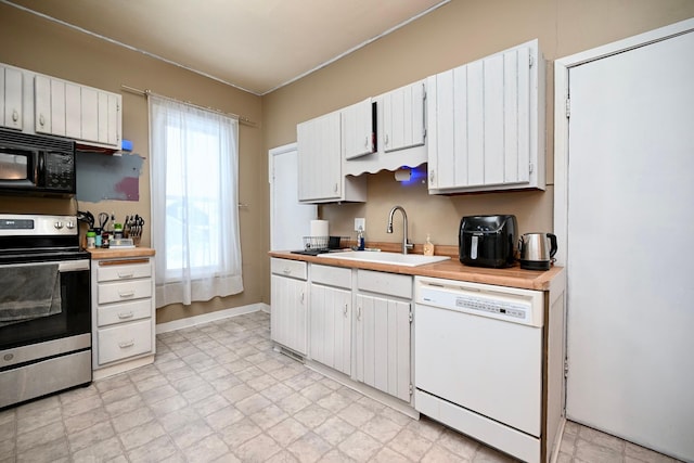 kitchen with white cabinetry, stainless steel range, white dishwasher, and sink