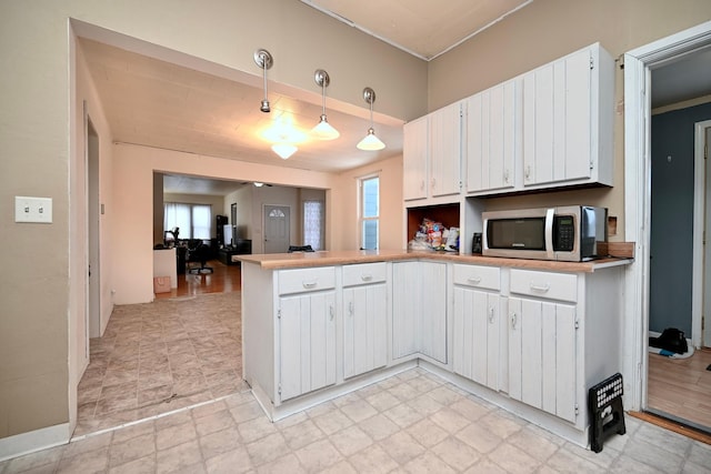 kitchen with pendant lighting, a healthy amount of sunlight, and white cabinets