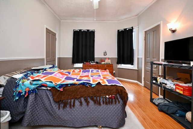 bedroom featuring a textured ceiling, ceiling fan, hardwood / wood-style flooring, and ornamental molding