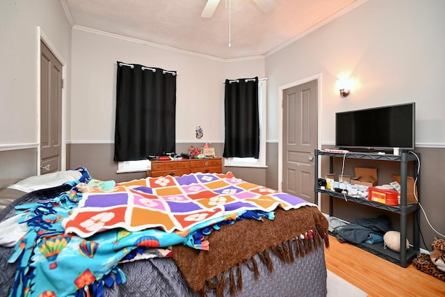 bedroom featuring a textured ceiling, hardwood / wood-style flooring, ceiling fan, and crown molding