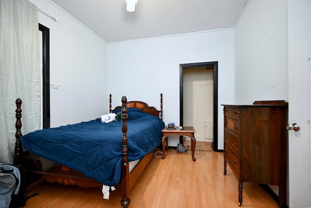 bedroom featuring light hardwood / wood-style flooring, ceiling fan, and ornamental molding