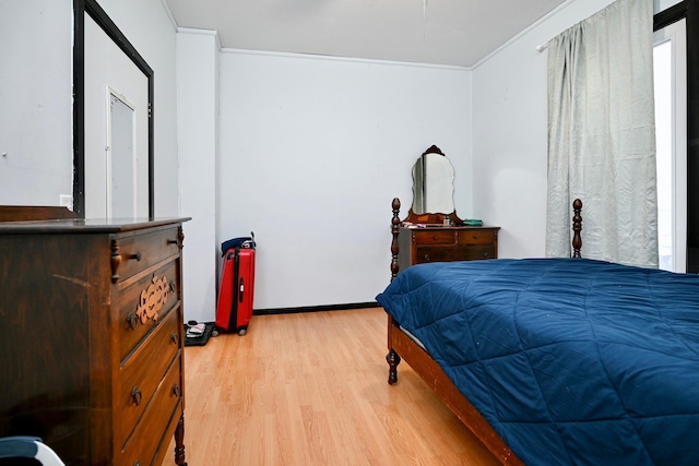 bedroom featuring crown molding and light hardwood / wood-style floors