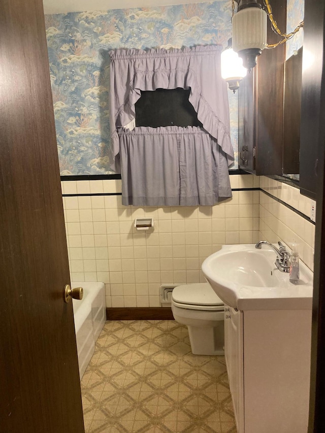 bathroom featuring toilet, vanity, and a washtub