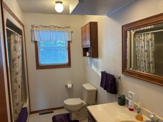 bathroom featuring vanity, a textured ceiling, and toilet