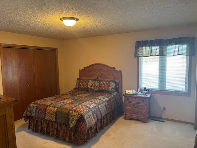 bedroom featuring carpet, a textured ceiling, and a closet
