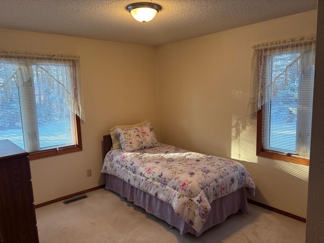 carpeted bedroom featuring a textured ceiling
