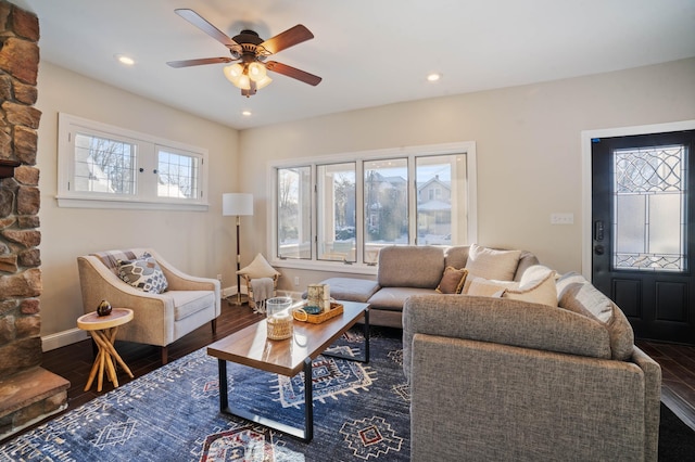 living room featuring dark hardwood / wood-style flooring, ceiling fan, and a healthy amount of sunlight