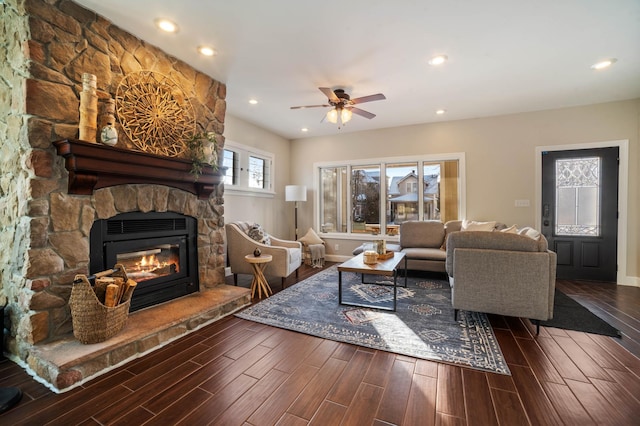 living room featuring a stone fireplace, ceiling fan, and hardwood / wood-style flooring