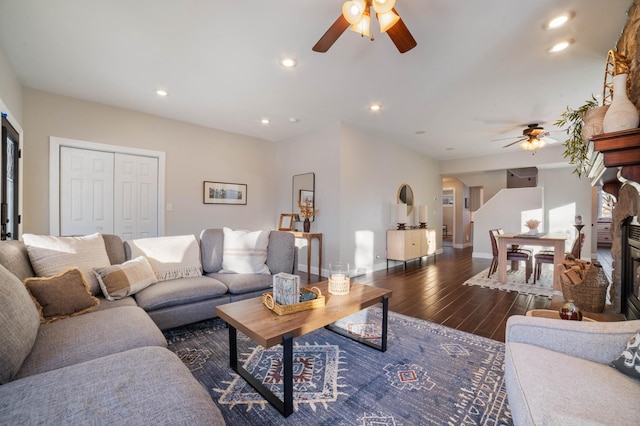 living room with ceiling fan and dark hardwood / wood-style flooring