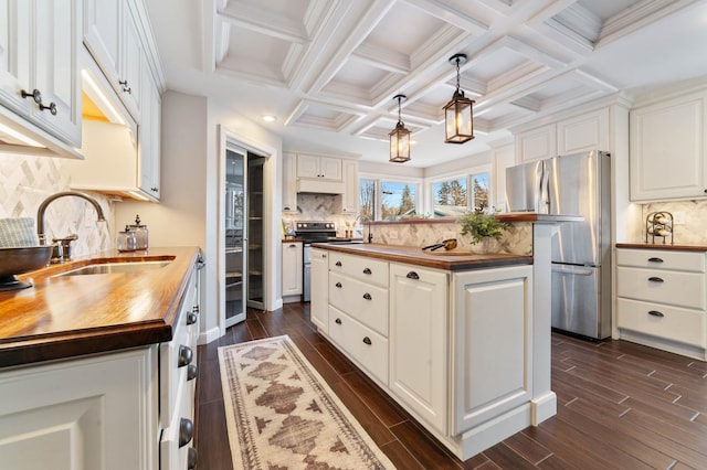 kitchen featuring wood counters, stainless steel appliances, and white cabinets