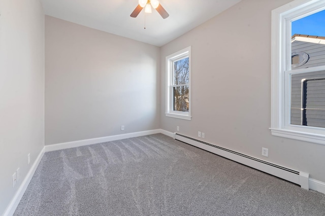 spare room with carpet flooring, plenty of natural light, and a baseboard heating unit