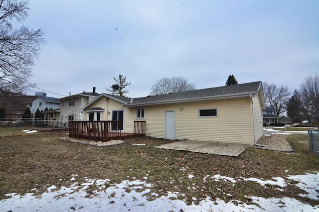 snow covered back of property featuring a wooden deck