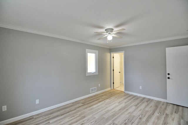 unfurnished room with a textured ceiling, light hardwood / wood-style flooring, and ornamental molding