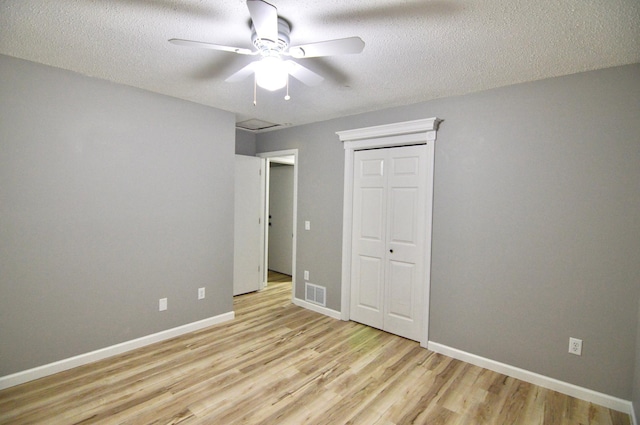 unfurnished bedroom with a textured ceiling, light hardwood / wood-style floors, and ceiling fan