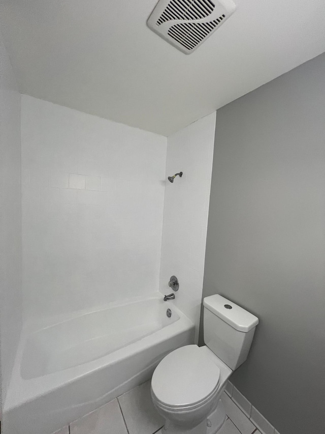 bathroom featuring tile patterned flooring, tub / shower combination, and toilet