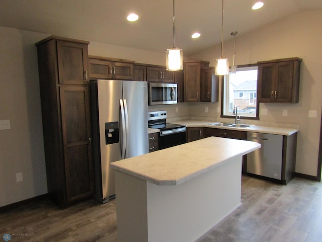 kitchen featuring sink, a kitchen island, stainless steel appliances, and lofted ceiling