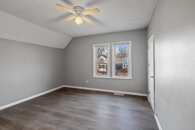 bonus room featuring dark hardwood / wood-style floors, ceiling fan, lofted ceiling, and a textured ceiling