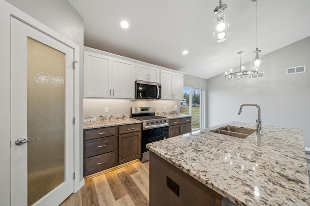 230 Eagle Ridge Dr, Roberts, WI 54023 - kitchen featuring stainless steel appliances, vaulted ceiling, white cabinetry, light wood finished floors, and light stone countertops