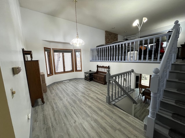 stairway with hardwood / wood-style flooring and an inviting chandelier