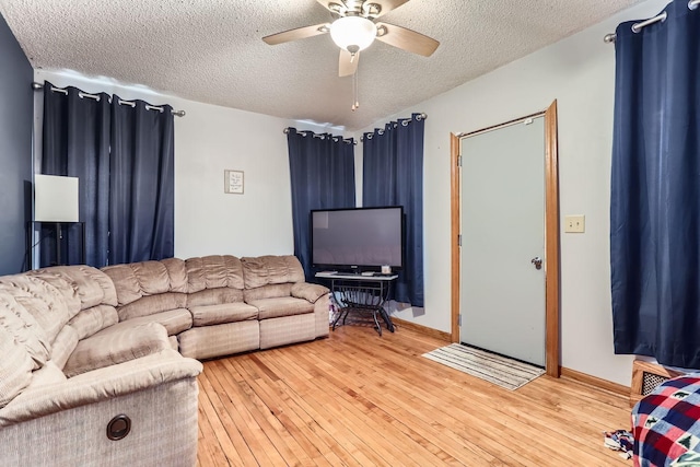 living room featuring a textured ceiling, ceiling fan, and wood-type flooring