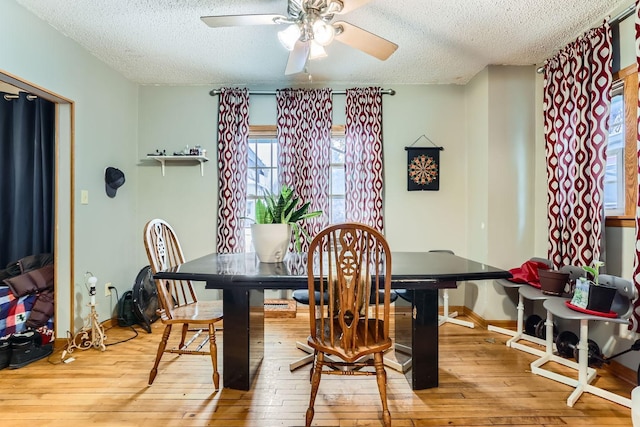 dining space with ceiling fan, a textured ceiling, and hardwood / wood-style flooring