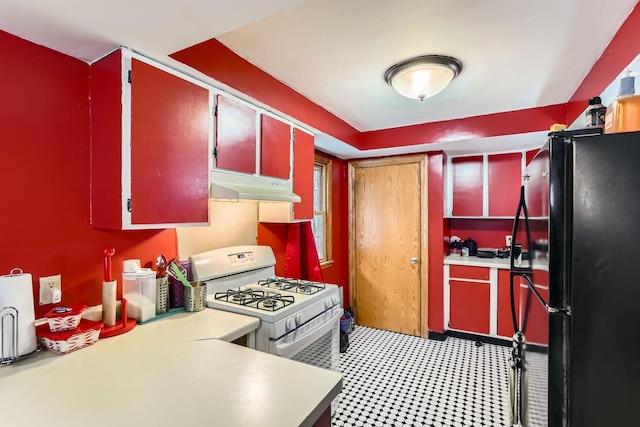 kitchen featuring black fridge and white gas range oven