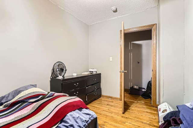 bedroom featuring a textured ceiling and light hardwood / wood-style flooring