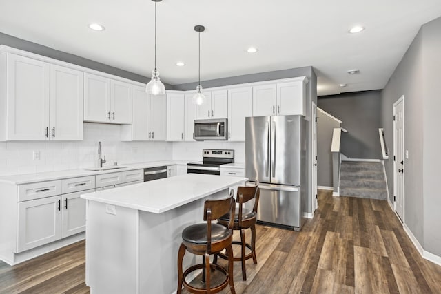 kitchen featuring light countertops, appliances with stainless steel finishes, a sink, and white cabinets